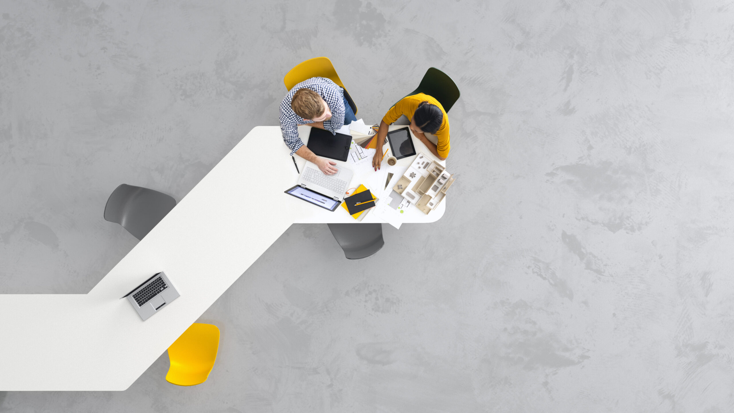 Overhead view of minimalistic office environment with two people collaborating.
