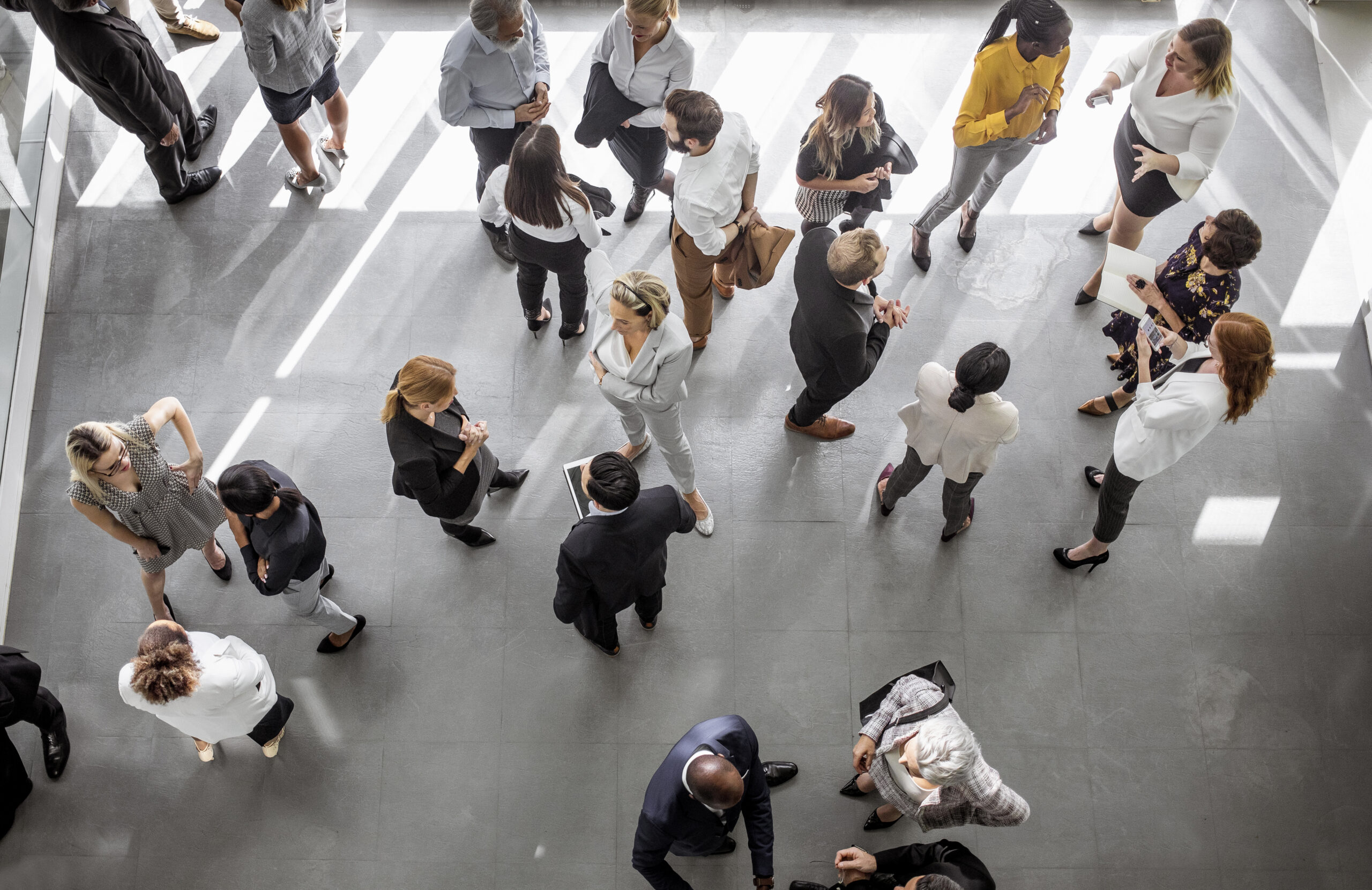 Overhead view of businesspeople having discussions in a large room.