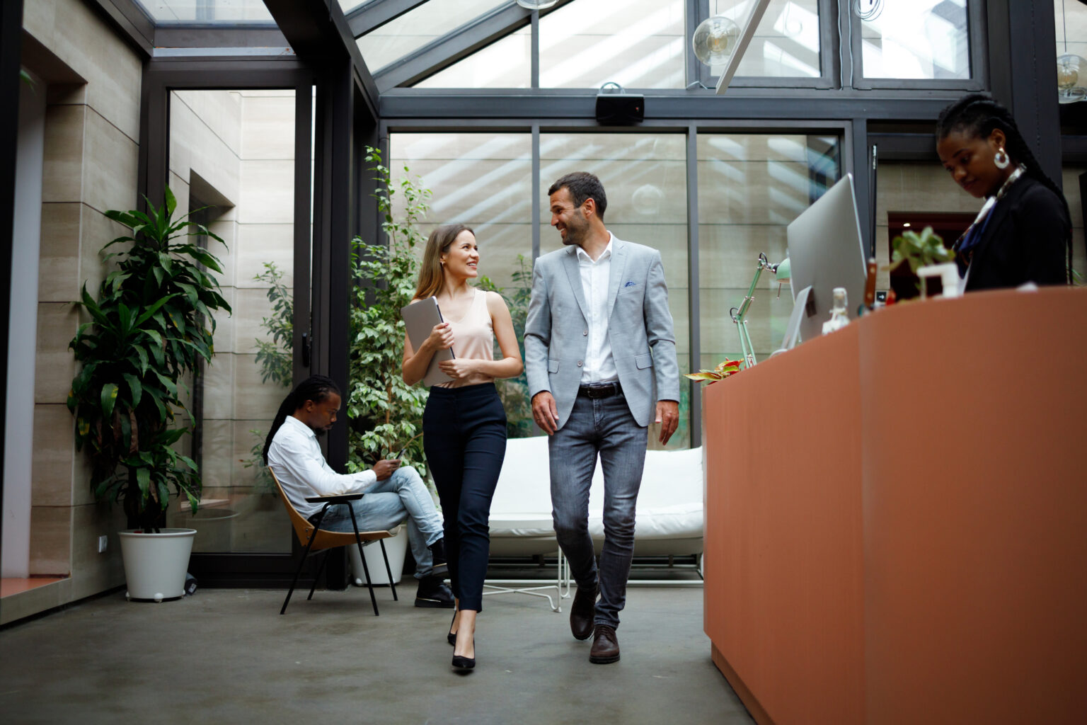 Businessman and businesswoman talking while walking through an office.