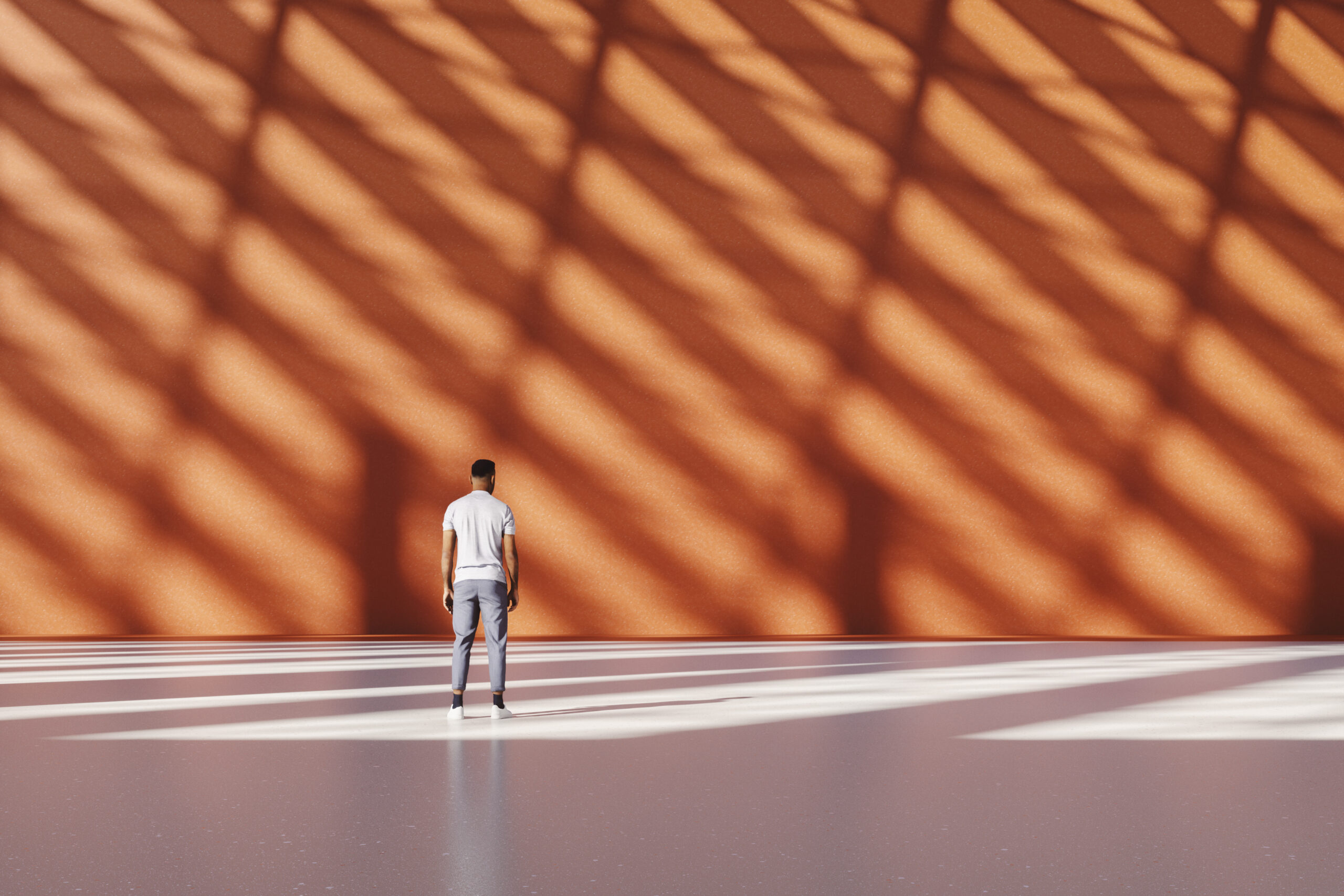 Artistic shot of a man standing in front of an orange wall with striped shadows.