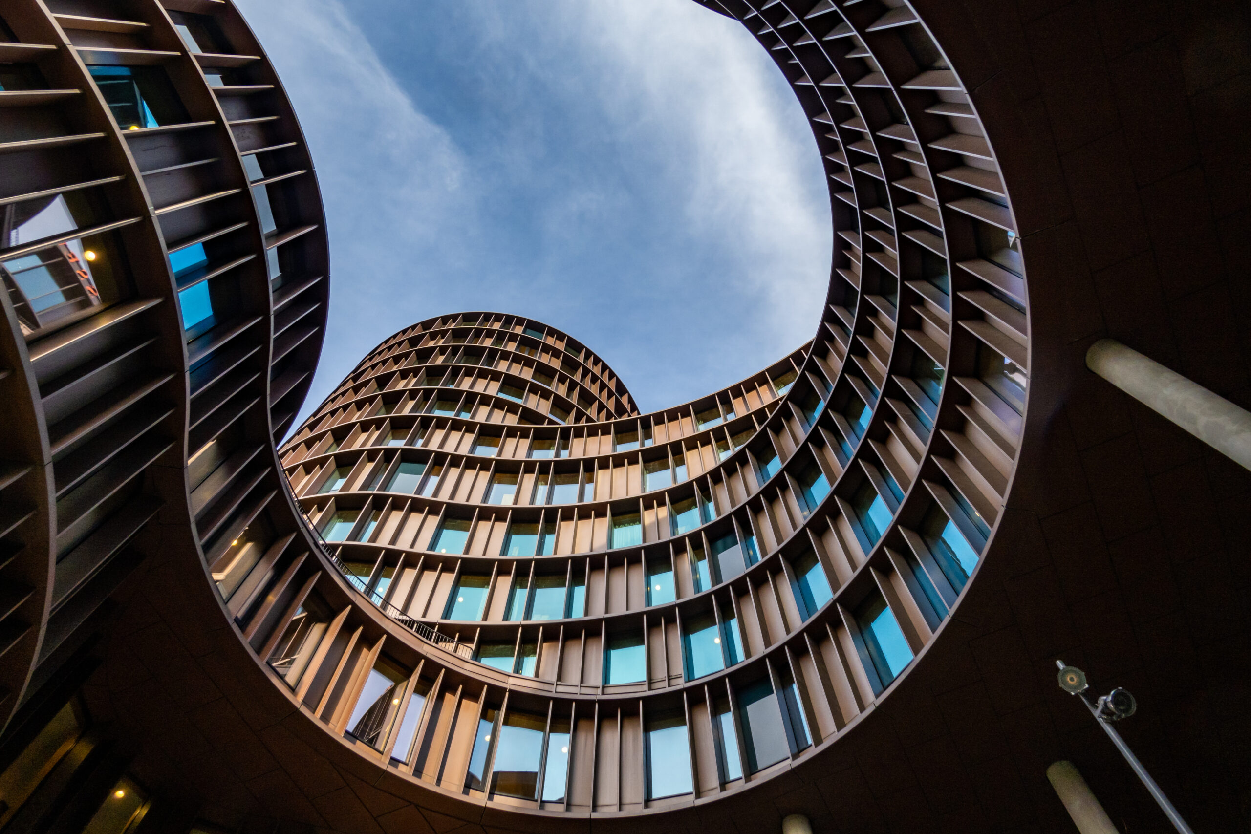 Upward view of curvilinear building architecture.