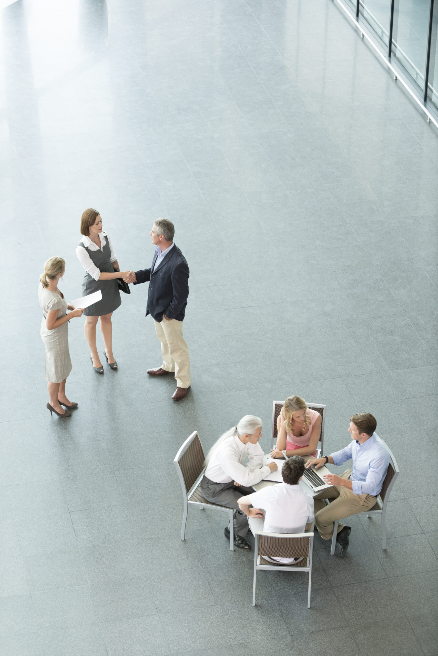 Overhead view of businesspeople meeting in a building lobby.