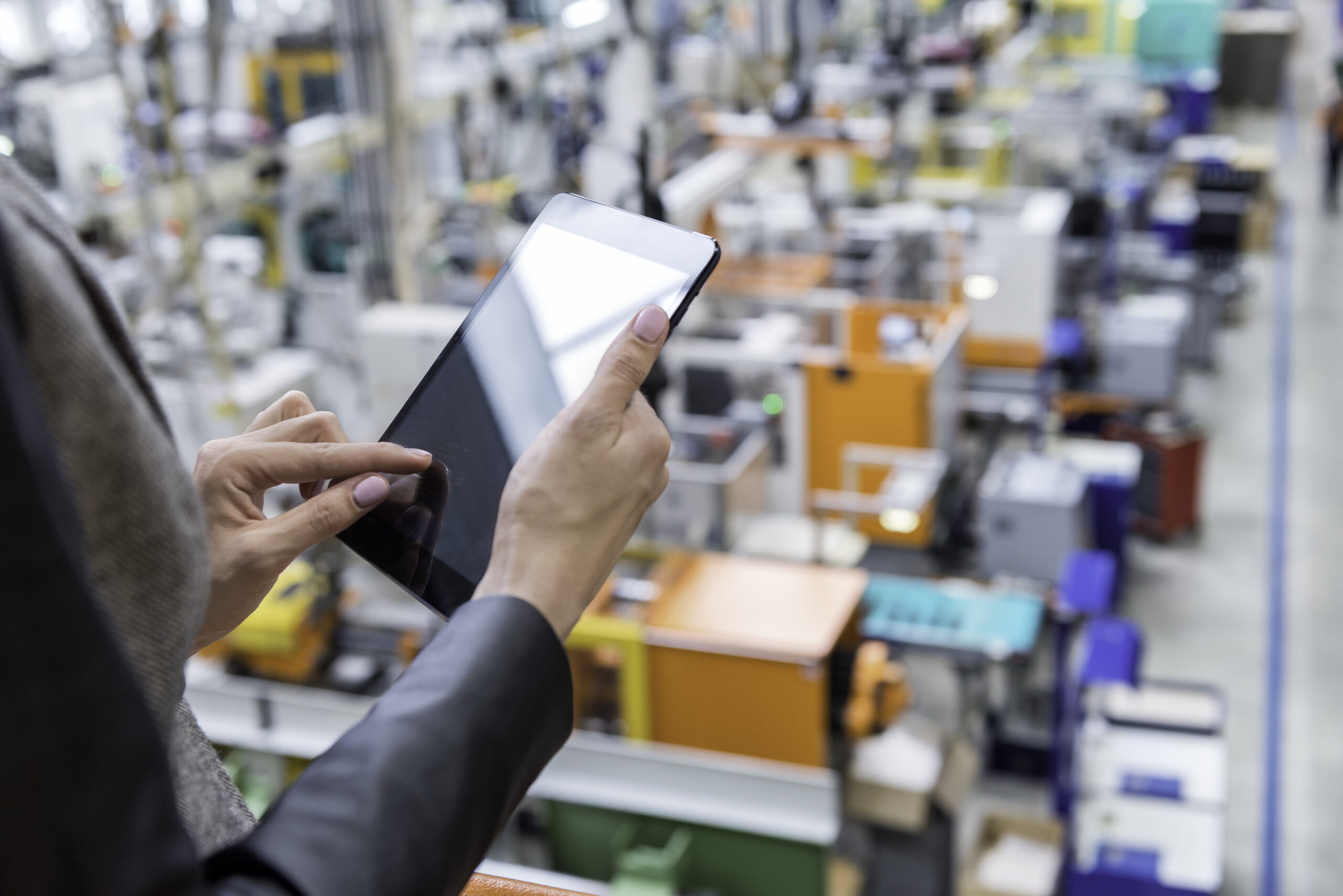 Woman in a factory working on a computer tablet.