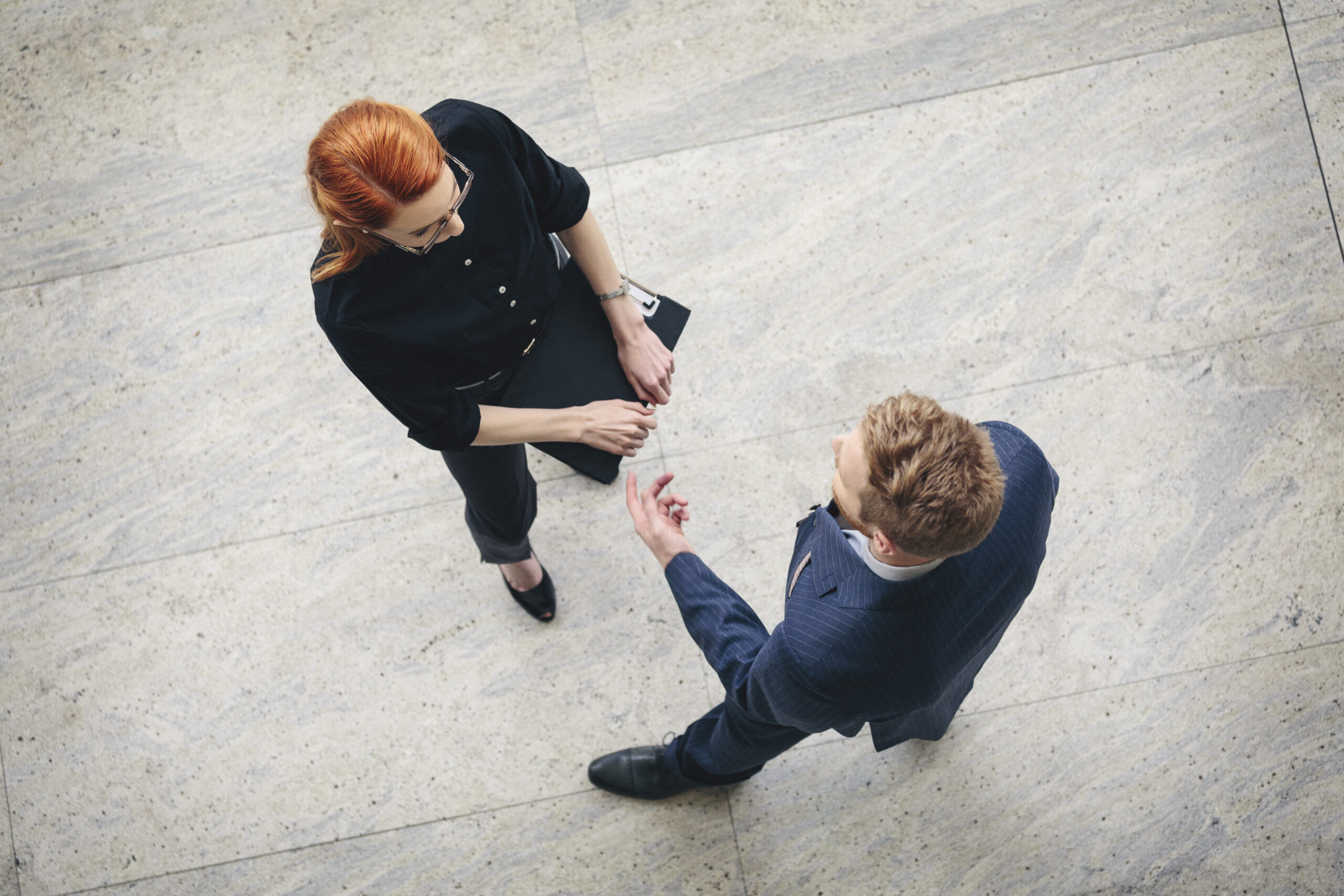 Overhead view of a businessman and businesswoman having a discussion.