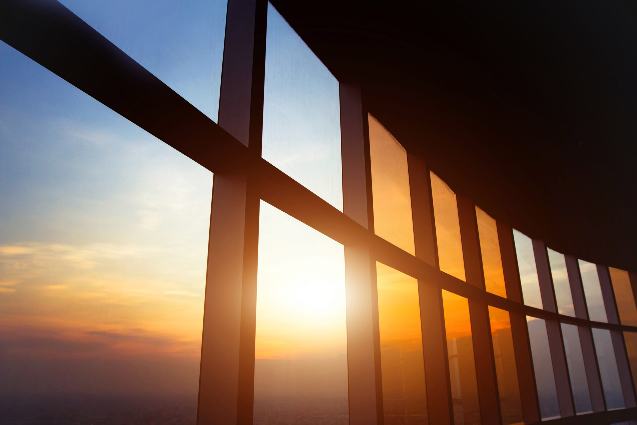 Sunset through a bank of framed office windows.