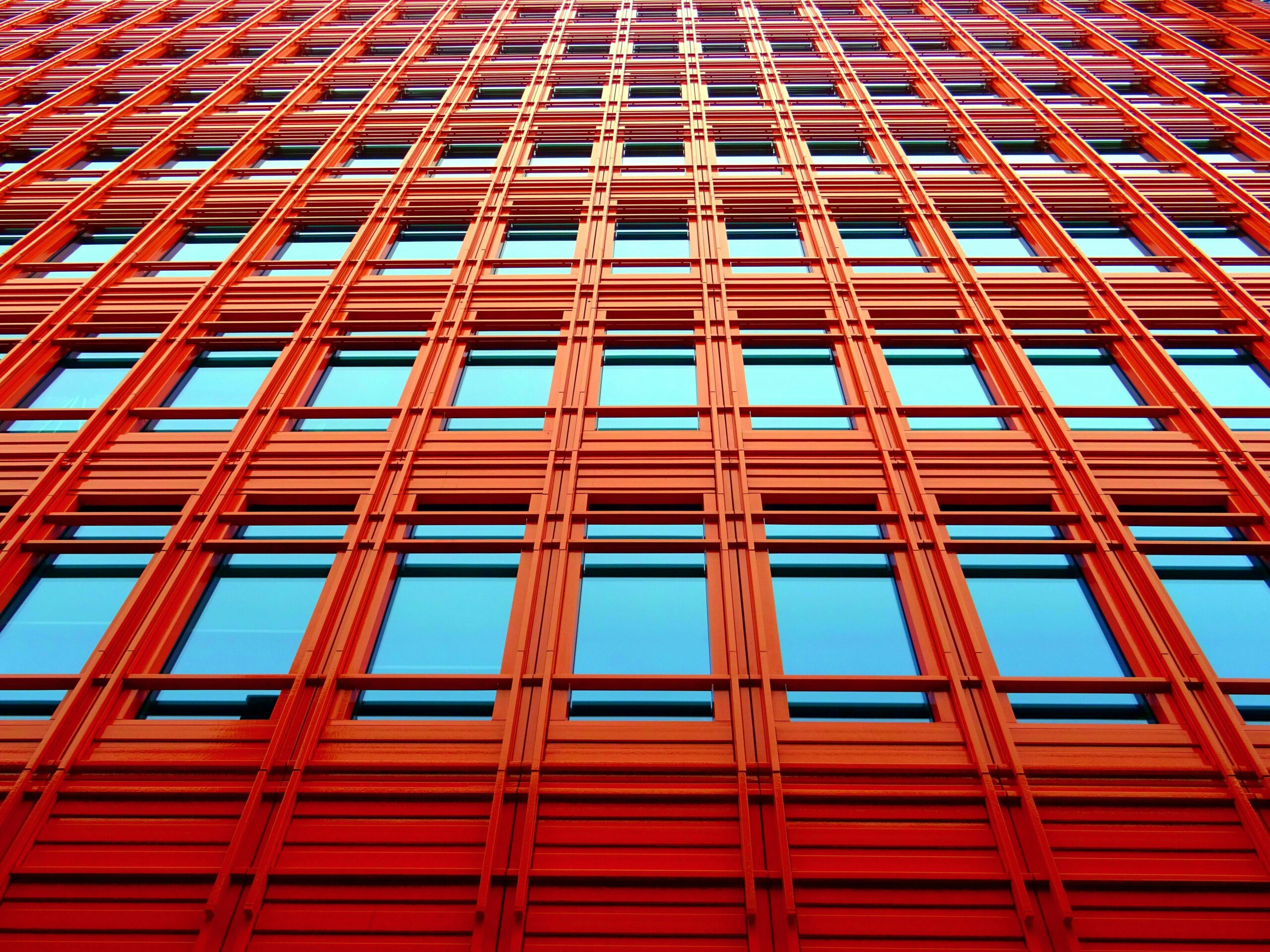 View looking up at a tall red building with windows